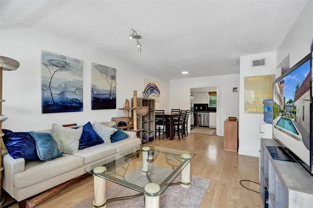 a living room with furniture kitchen view and a large window