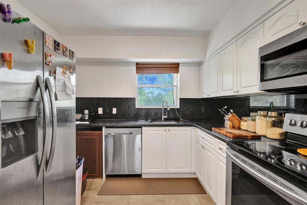 601 Southeast 5th Court, Unit 309 Fort Lauderdale, FL 33301 - Photo 7 of 17 a kitchen with stainless steel appliances granite countertop a sink stove and refrigerator