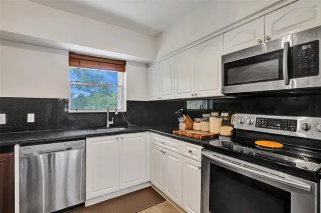 a kitchen with stainless steel appliances a sink stove and microwave
