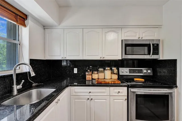 a kitchen with a sink stove and microwave