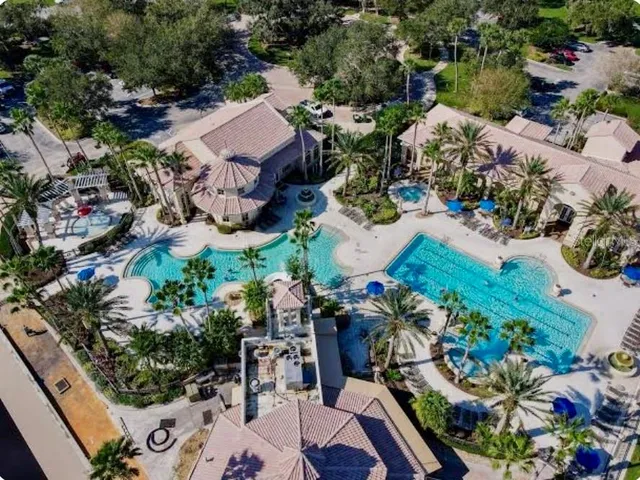 an aerial view of a house with a garden and lake view