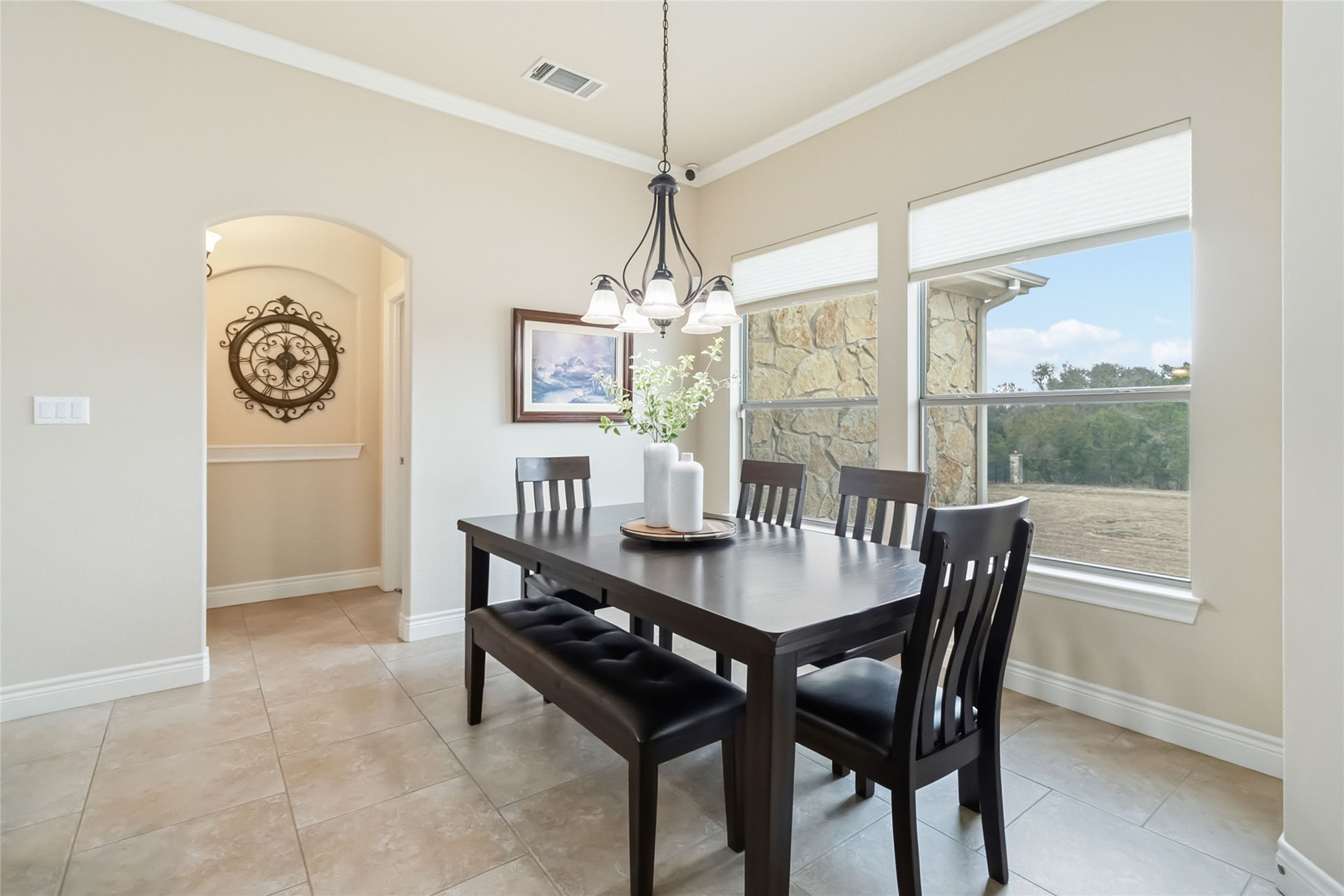 108 Standing Oak Drive Georgetown, TX 78633 - Photo 13 of 37 Bright dining area featuring large windows, a statement chandelier, and easy flow to the kitchen and living spaces.