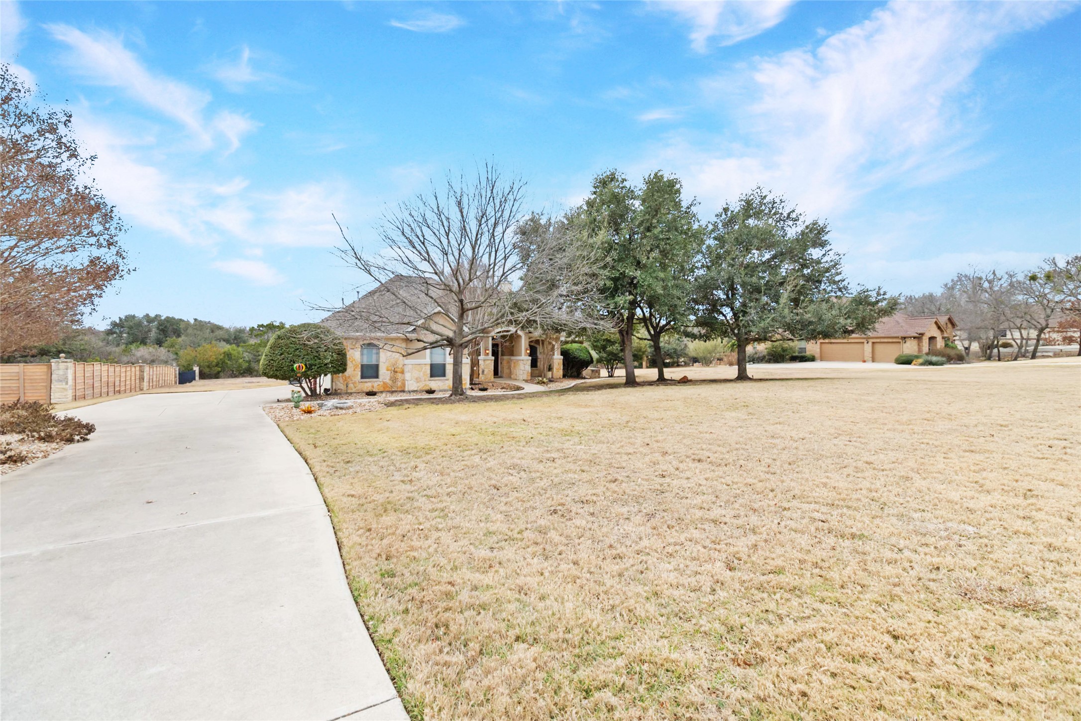 108 Standing Oak Drive Georgetown, TX 78633 - Photo 2 of 37 A sweeping front view highlights the long private driveway, expansive front lawn, and mature trees, creating a peaceful sense of space and separation from the road.