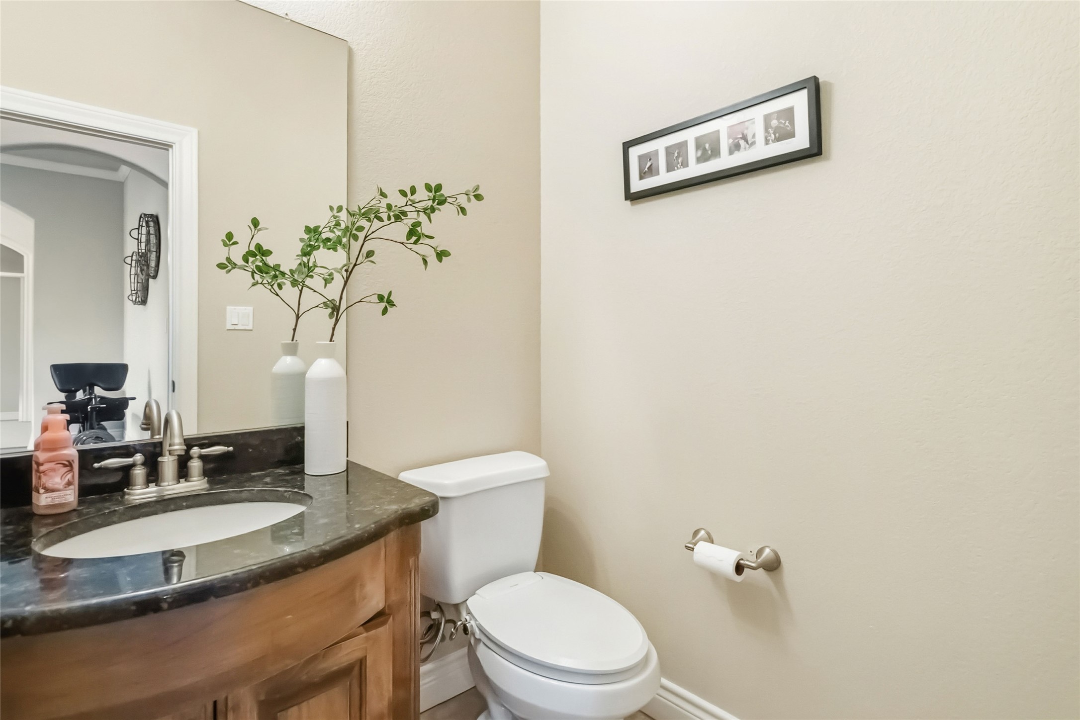 108 Standing Oak Drive Georgetown, TX 78633 - Photo 25 of 37 Convenient half bath with granite countertop, undermount sink, and warm wood cabinetry, ideal for guests.