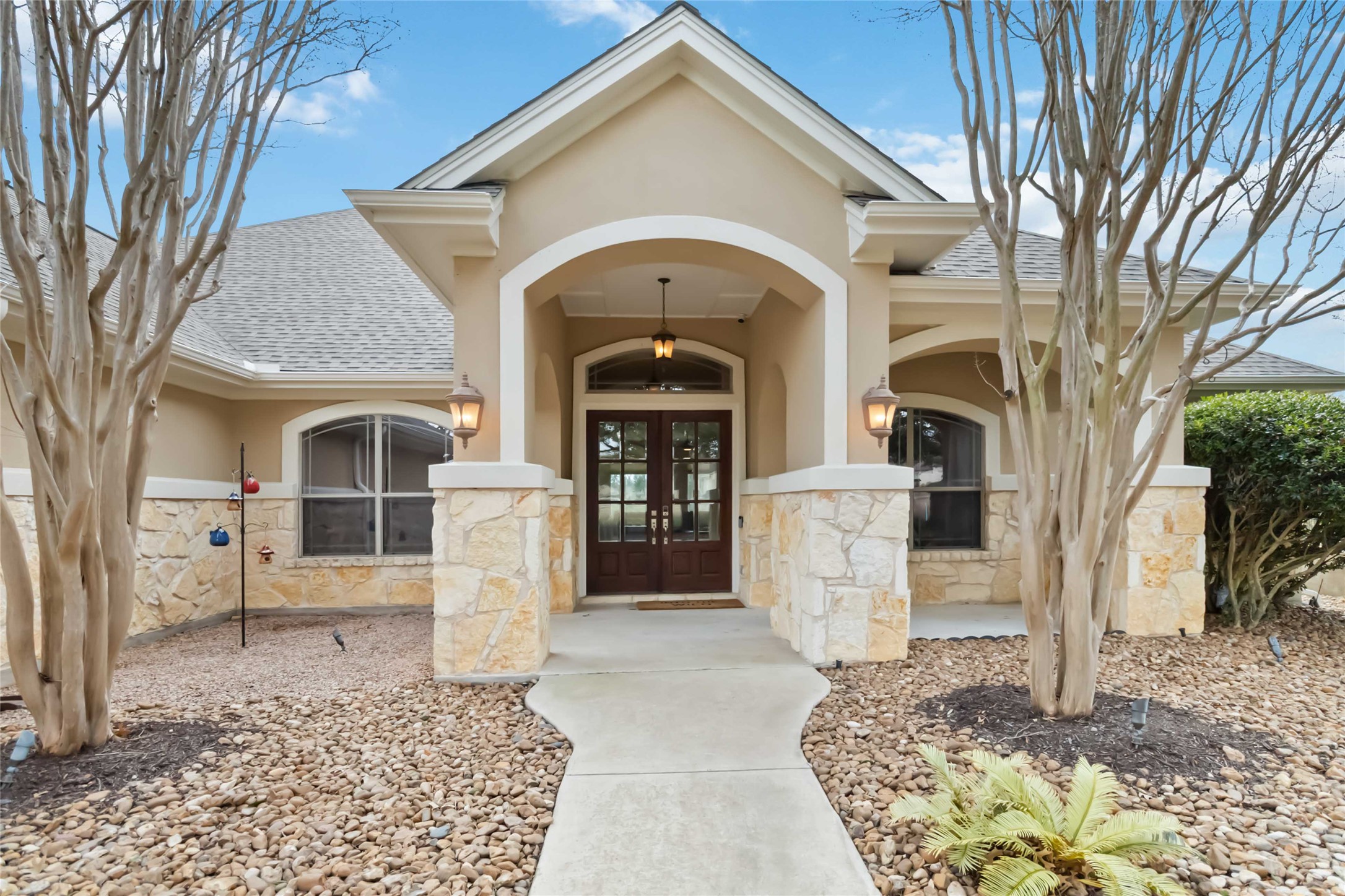 108 Standing Oak Drive Georgetown, TX 78633 - Photo 3 of 37 A welcoming covered front porch with stone accents, arched entry, and double doors creates a strong first impression and inviting arrival.
