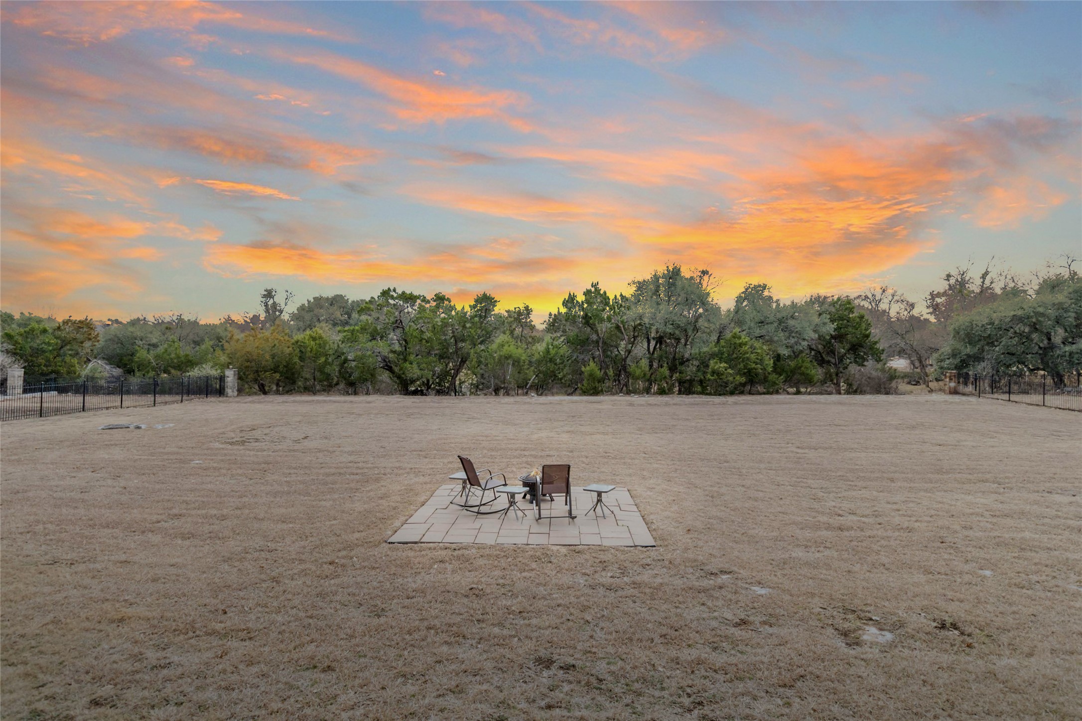 108 Standing Oak Drive Georgetown, TX 78633 - Photo 36 of 37 This view captures the scale of the backyard and the inviting outdoor setup, with a fire pit creating an ideal space for evenings outside.