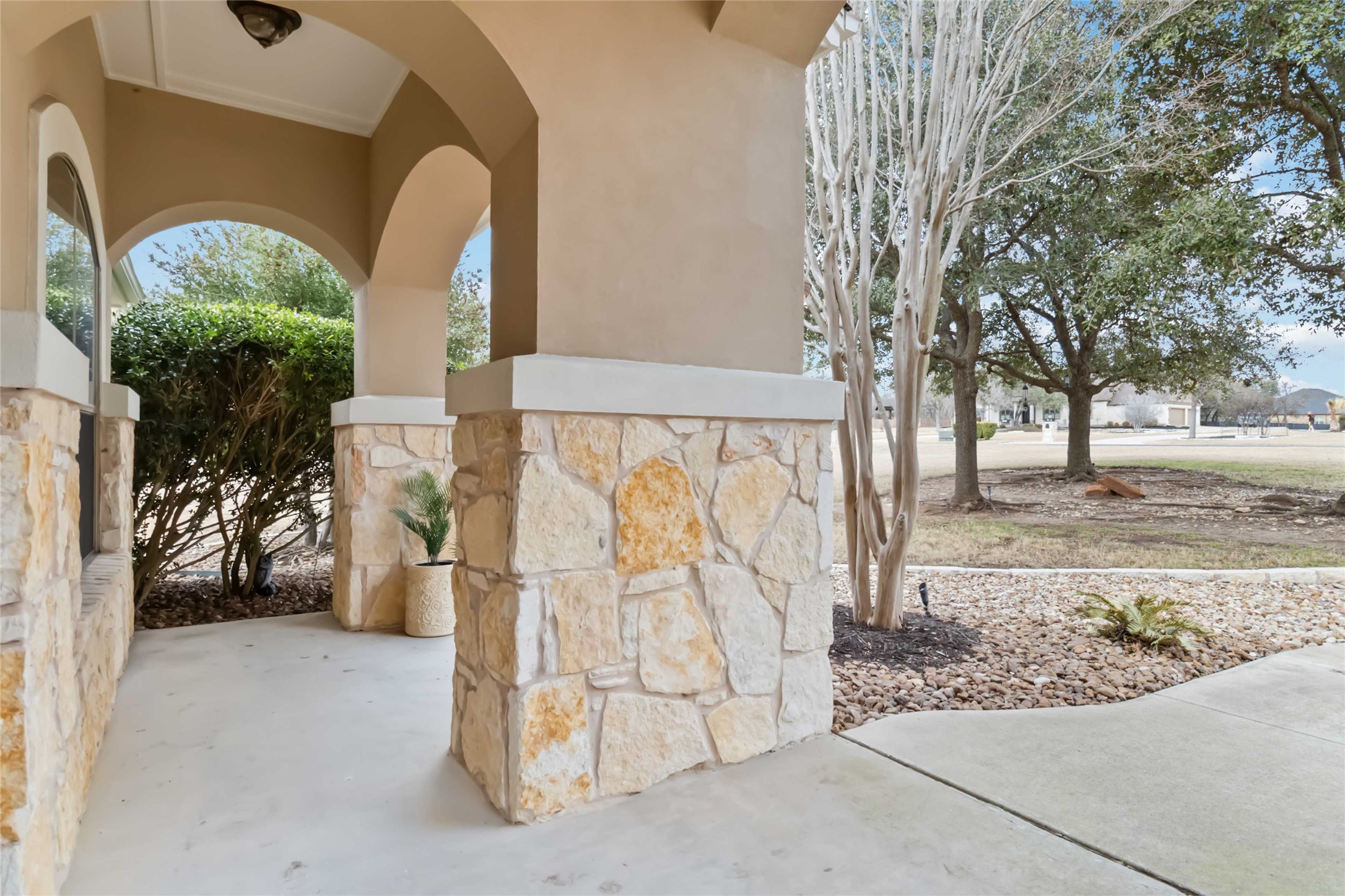 108 Standing Oak Drive Georgetown, TX 78633 - Photo 5 of 37 A covered front porch showcases stonework and arched details, creating a classic entry with peaceful outdoor views.