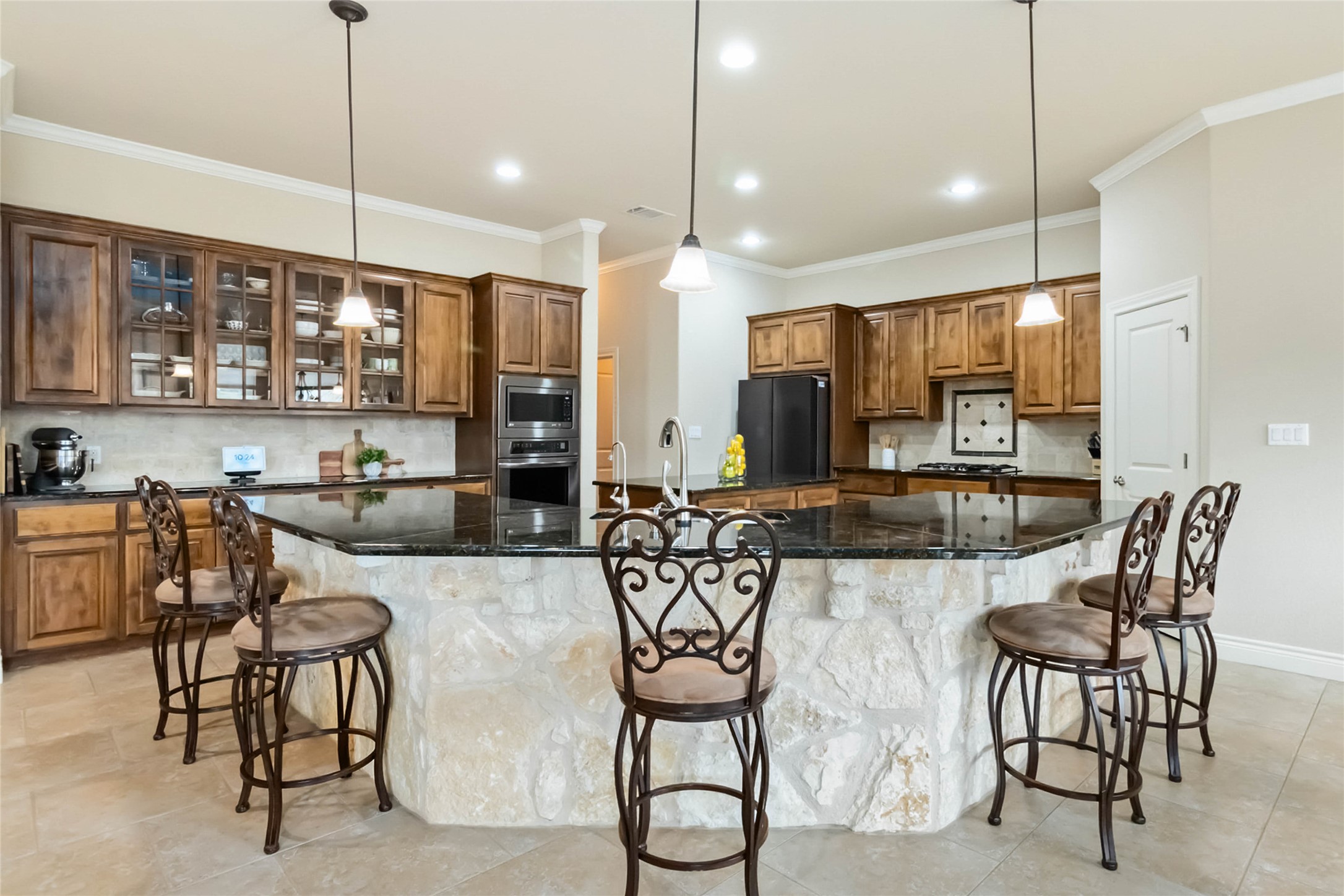 108 Standing Oak Drive Georgetown, TX 78633 - Photo 9 of 37 Spacious chef’s kitchen featuring an oversized stone island, granite countertops, custom cabinetry, and ample seating, ideal for everyday living and entertaining.
