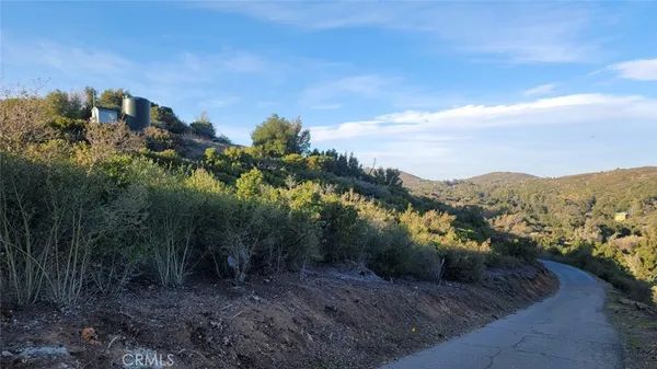 a view of a dry yard with mountains in the background