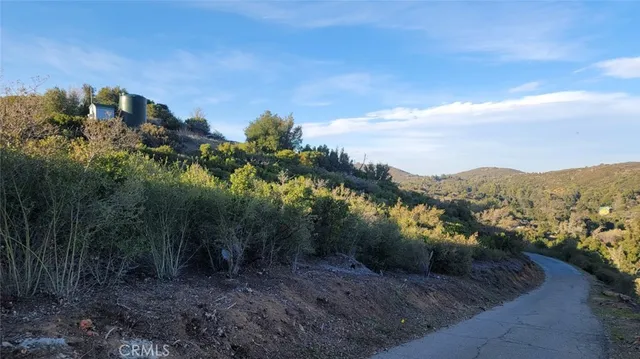 a view of a dry yard with mountains in the background