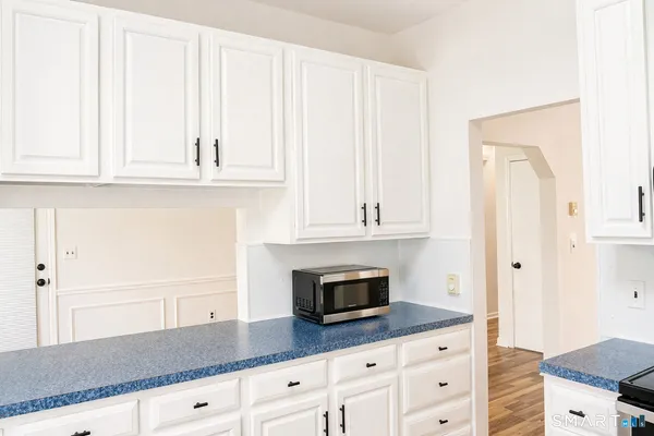 a kitchen with granite countertop white cabinets and stainless steel appliances