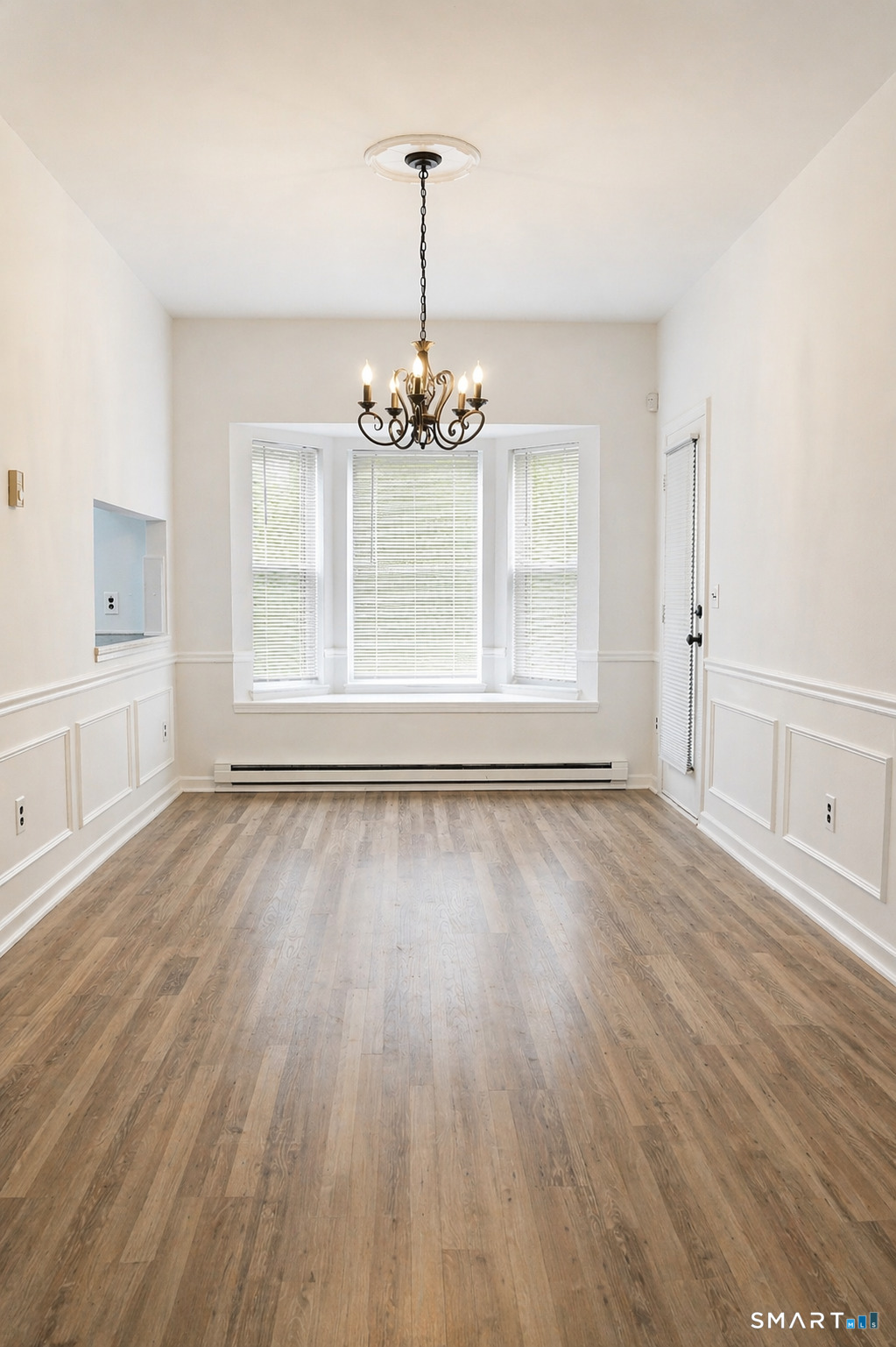 905 Oronoke Road, Unit 13 Waterbury, CT 06708 - Photo 8 of 18 an empty room with wooden floor and windows