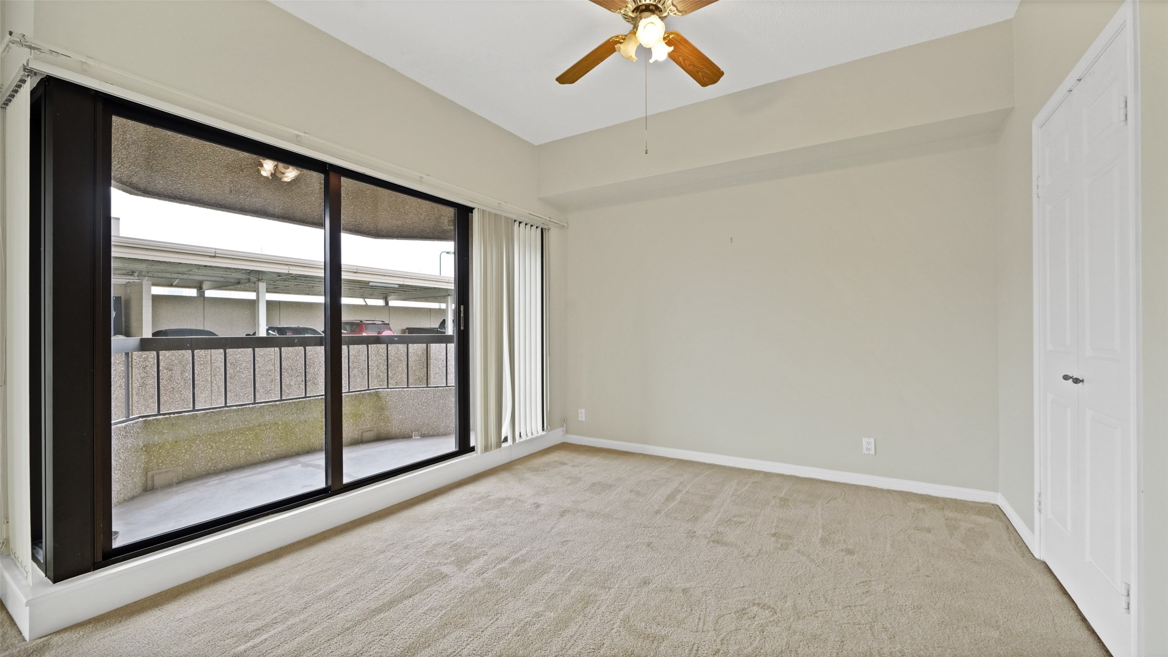 2001 Holcombe Boulevard, Unit 404 Houston, TX 77030 - Photo 14 of 33 This room features neutral walls, a ceiling fan, and large sliding glass doors leading to a private balcony, providing ample natural light.
