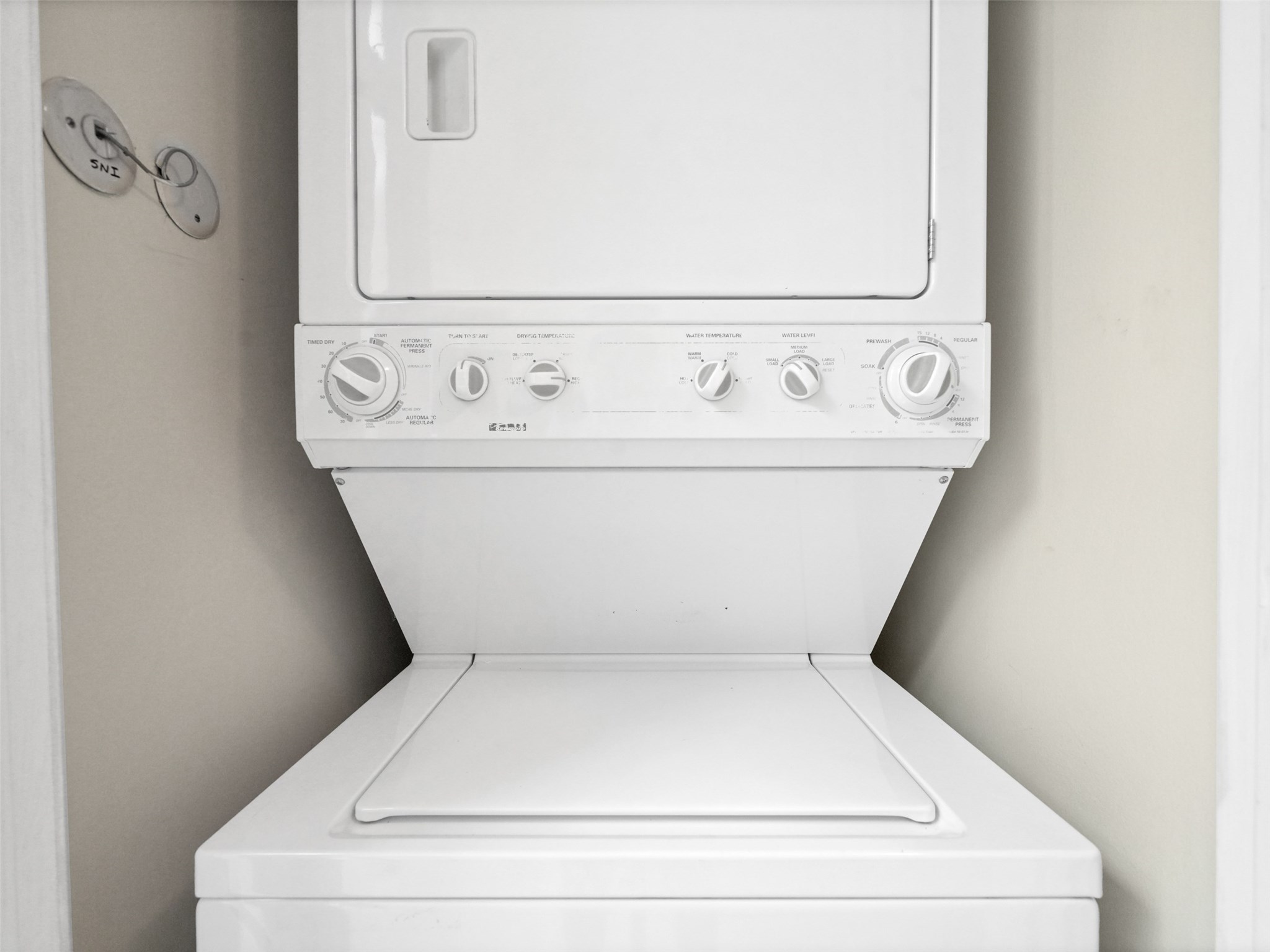 2001 Holcombe Boulevard, Unit 404 Houston, TX 77030 - Photo 15 of 33 This image shows a compact, white stacked washer and dryer unit, ideal for small spaces. The setup is efficient, with easy-to-use controls, perfect for maximizing laundry convenience in a home.