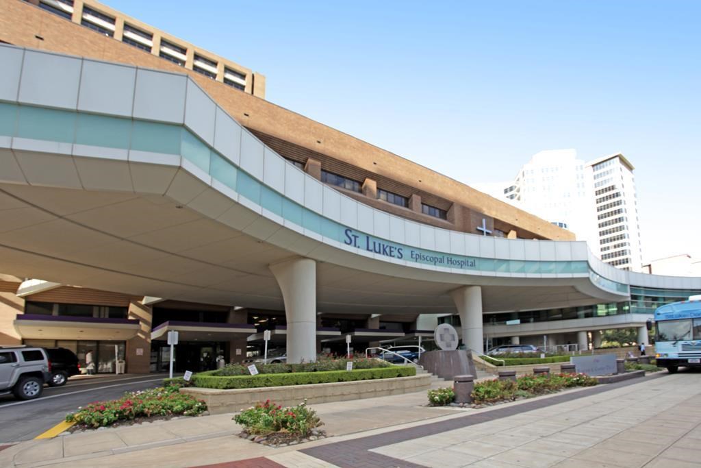 2001 Holcombe Boulevard, Unit 404 Houston, TX 77030 - Photo 24 of 33 This photo shows a large hospital with a modern design, featuring curved architecture and a spacious entrance area. It's surrounded by a well-maintained landscape and is situated in an urban environment with nearby high-rise buildings. Ideal for home buyers seeking proximity to healthcare facilities.