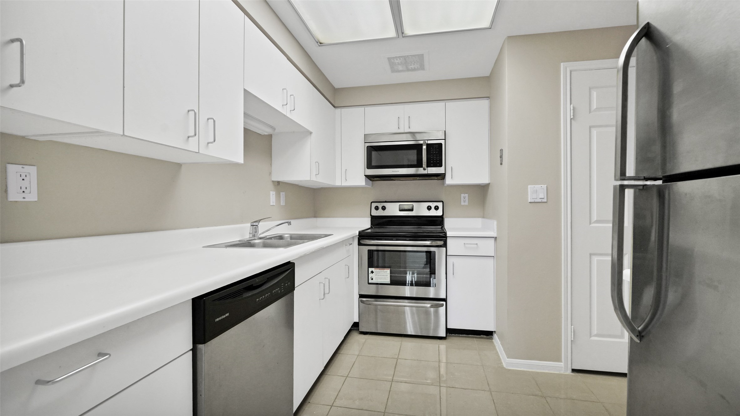 2001 Holcombe Boulevard, Unit 404 Houston, TX 77030 - Photo 6 of 33 This modern kitchen features sleek stainless steel appliances, bright white cabinetry, and ample counter space, creating a clean and functional cooking area.