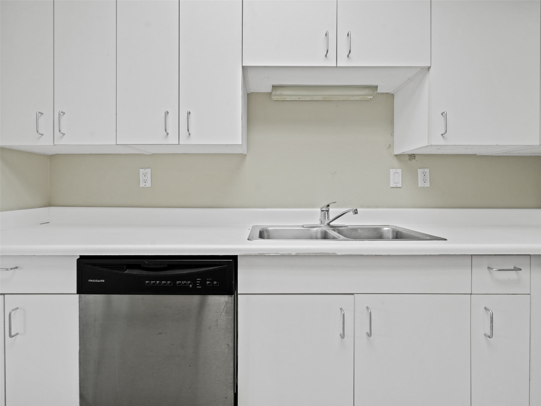 2001 Holcombe Boulevard, Unit 404 Houston, TX 77030 - Photo 7 of 33 This kitchen features sleek white cabinetry, a double stainless steel sink, and a built-in dishwasher for modern convenience.