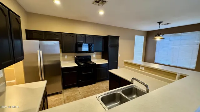 a kitchen with stainless steel appliances kitchen island granite countertop a refrigerator and a stove top oven
