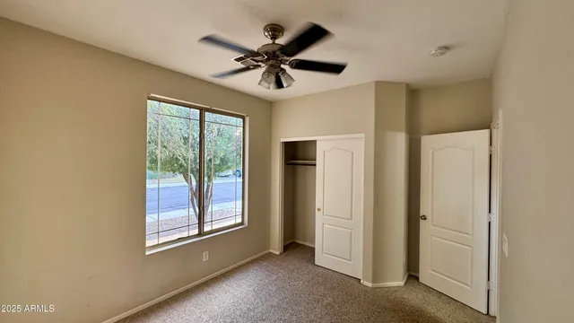 a view of a livingroom with a ceiling fan and window