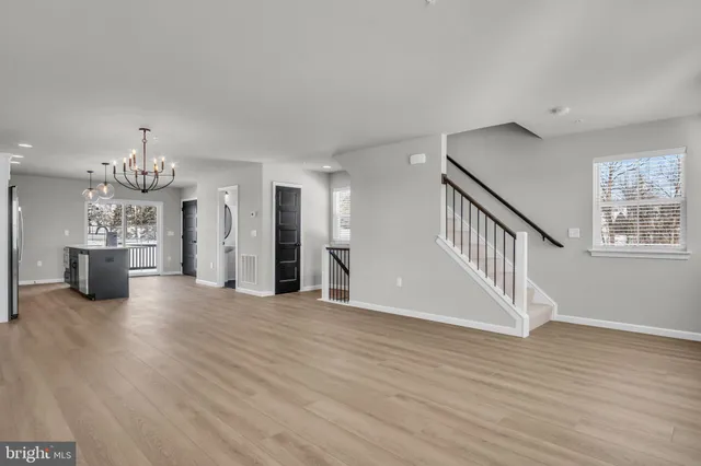 a view of empty room with wooden floor and window