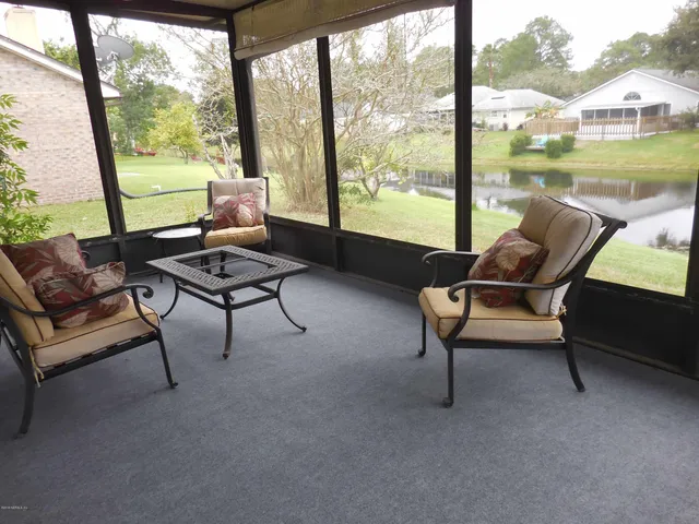 a living room with furniture and a floor to ceiling window