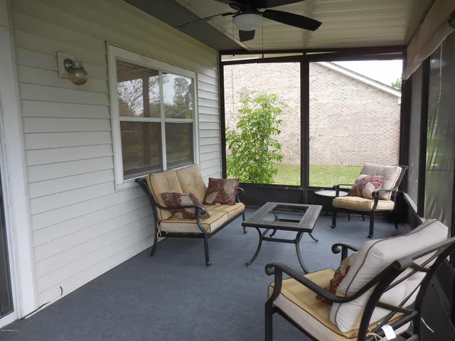a living room with furniture and floor to ceiling windows