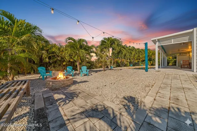 a backyard of a house with table and chairs
