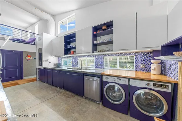 a utility room with dryer washer and a view of living room