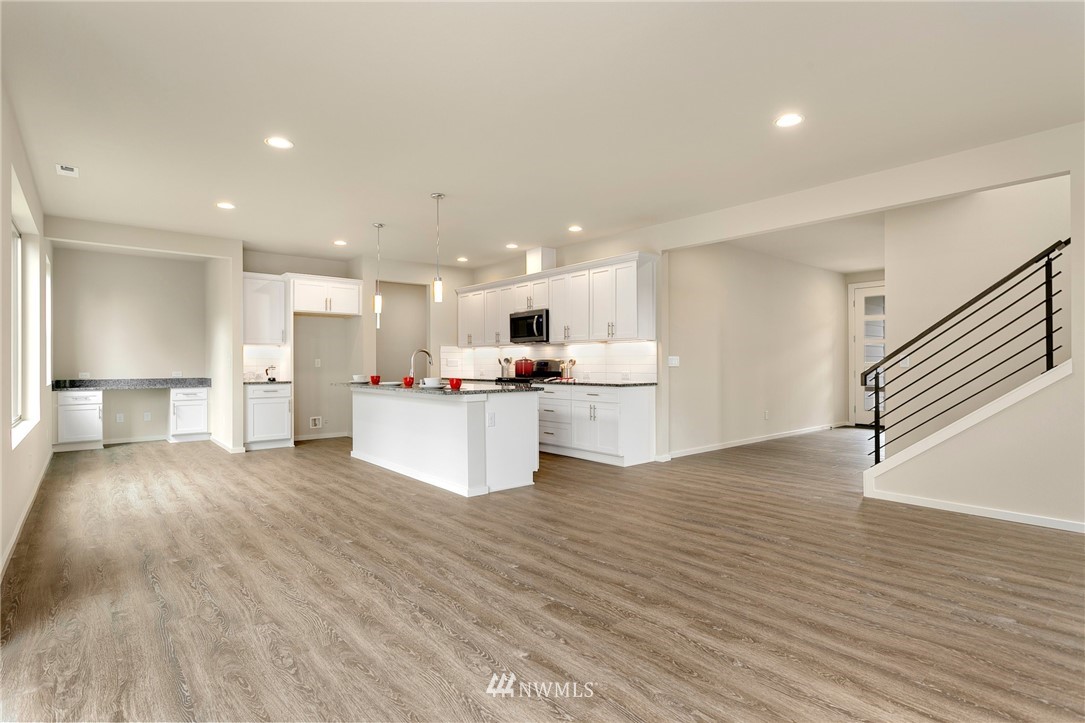 309 Southwest 3rd Court, Unit 9 Renton, WA 98057 - Photo 11 of 25 a view of kitchen with kitchen island a sink wooden floor and a refrigerator
