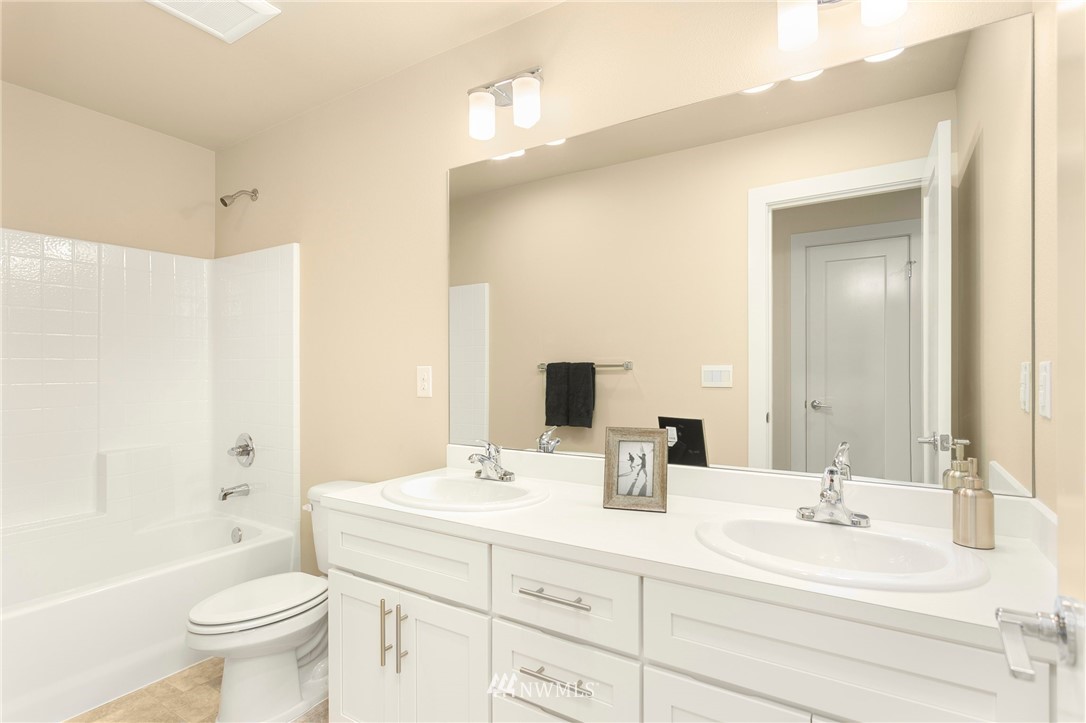 309 Southwest 3rd Court, Unit 9 Renton, WA 98057 - Photo 22 of 25 a bathroom with a sink a toilet and a large mirror