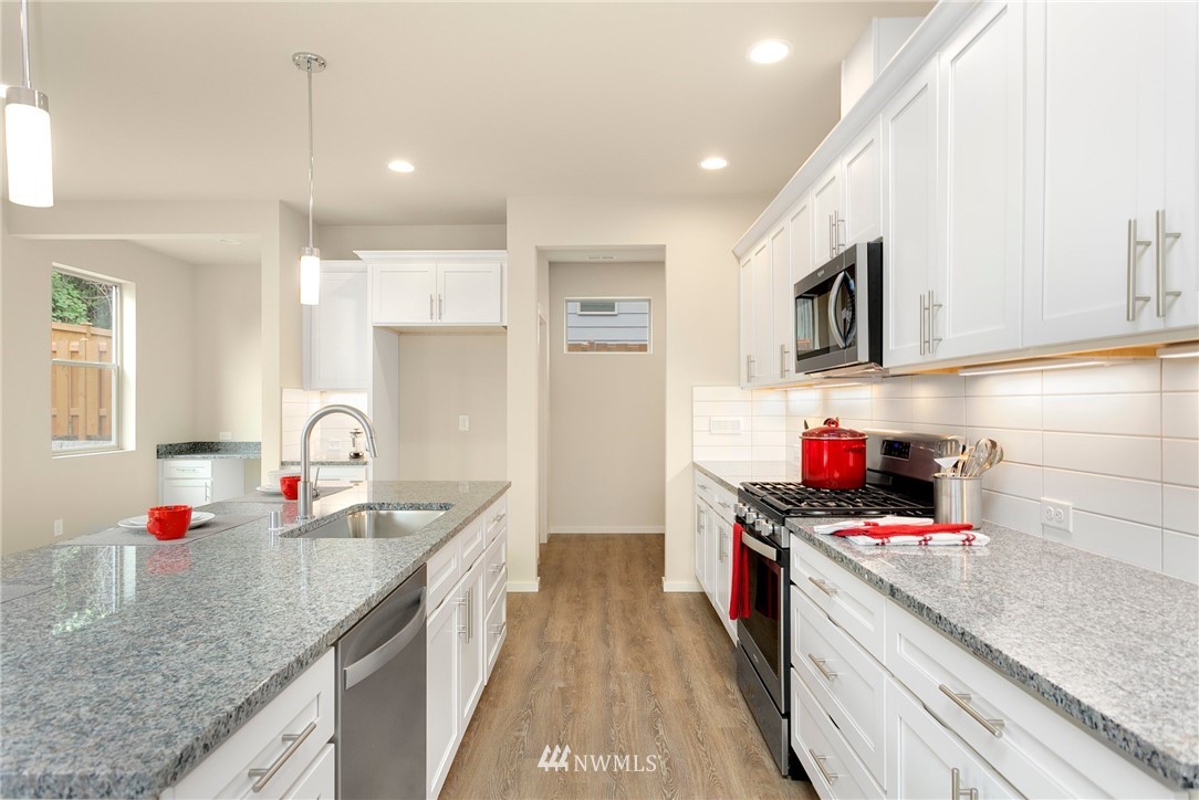 309 Southwest 3rd Court, Unit 9 Renton, WA 98057 - Photo 10 of 25 a kitchen with stainless steel appliances granite countertop a sink stove and refrigerator