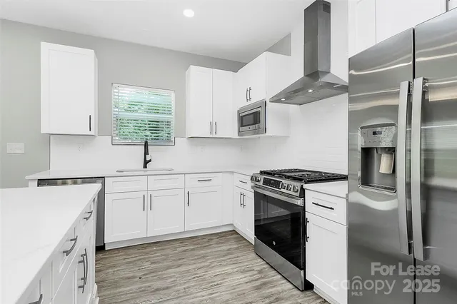 a kitchen with stainless steel appliances granite countertop a stove a sink and a refrigerator