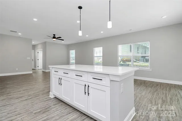 a kitchen with stainless steel appliances granite countertop a sink a stove and a wooden floors