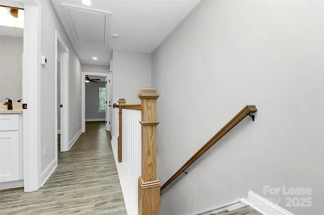 a view of a hallway with wooden floor and staircase