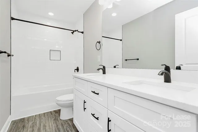 a bathroom with a tub sink toilet and a mirror