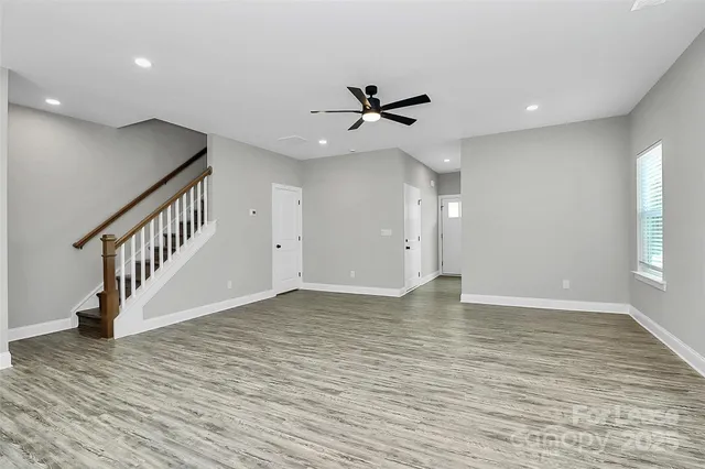 a view of an empty room with a window and wooden floor