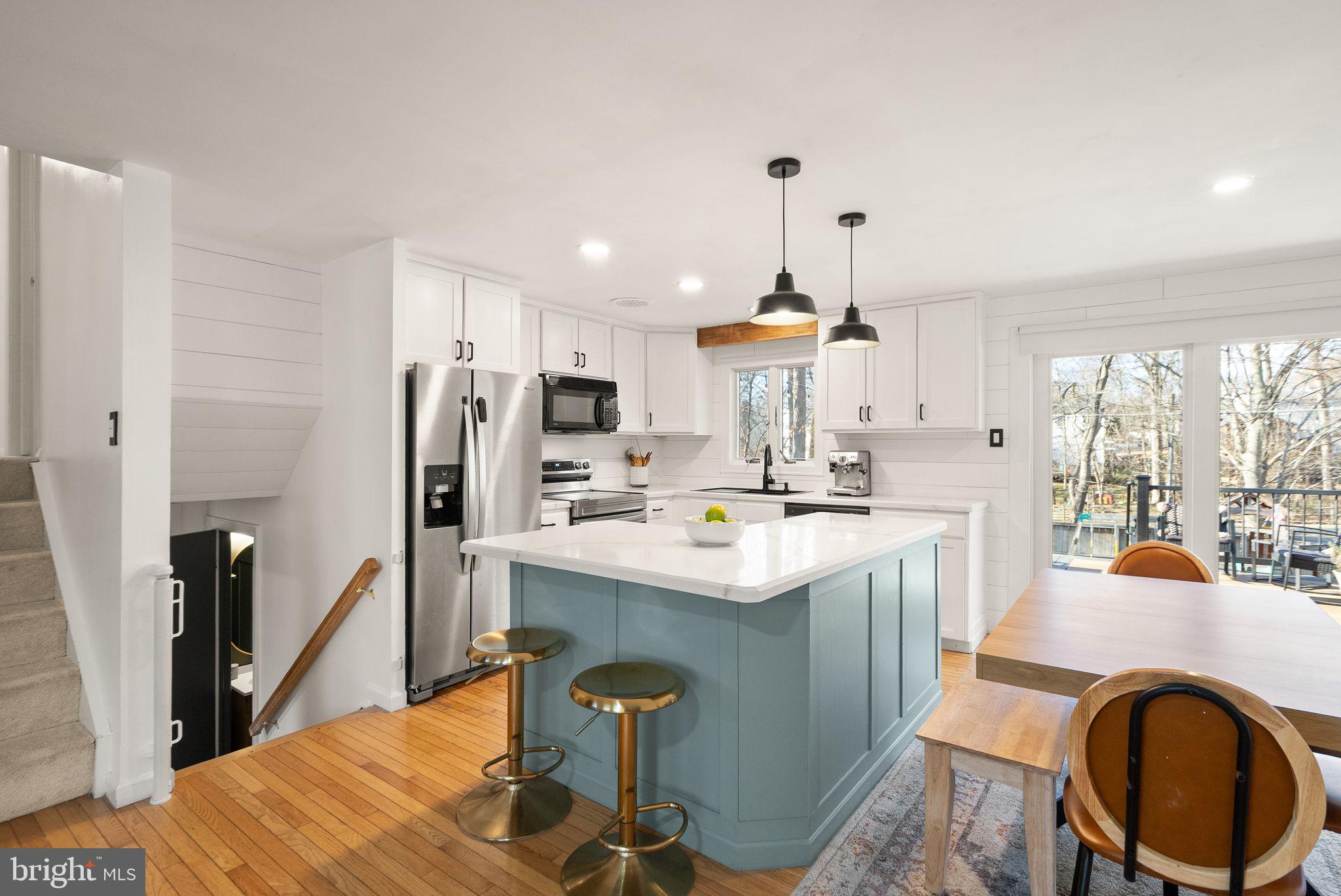 7902 Cliff Rock Court Springfield, VA 22153 - Photo 11 of 57 a kitchen with stainless steel appliances a dining table chairs stove refrigerator and cabinets