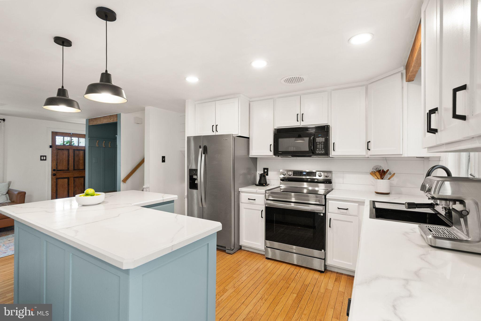 7902 Cliff Rock Court Springfield, VA 22153 - Photo 14 of 57 a kitchen with stainless steel appliances a stove a sink a refrigerator a center island and cabinets