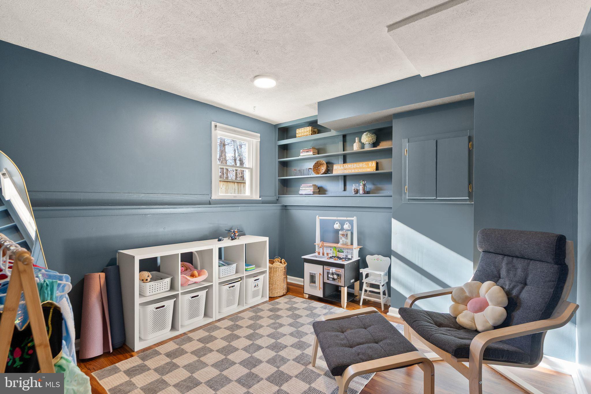 7902 Cliff Rock Court Springfield, VA 22153 - Photo 32 of 57 a living room with furniture a rug and a bookshelf
