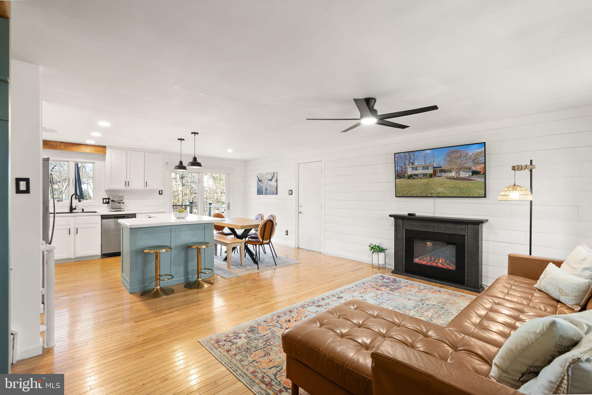 7902 Cliff Rock Court Springfield, VA 22153 - Photo 5 of 57 a living room with furniture a fireplace and kitchen view