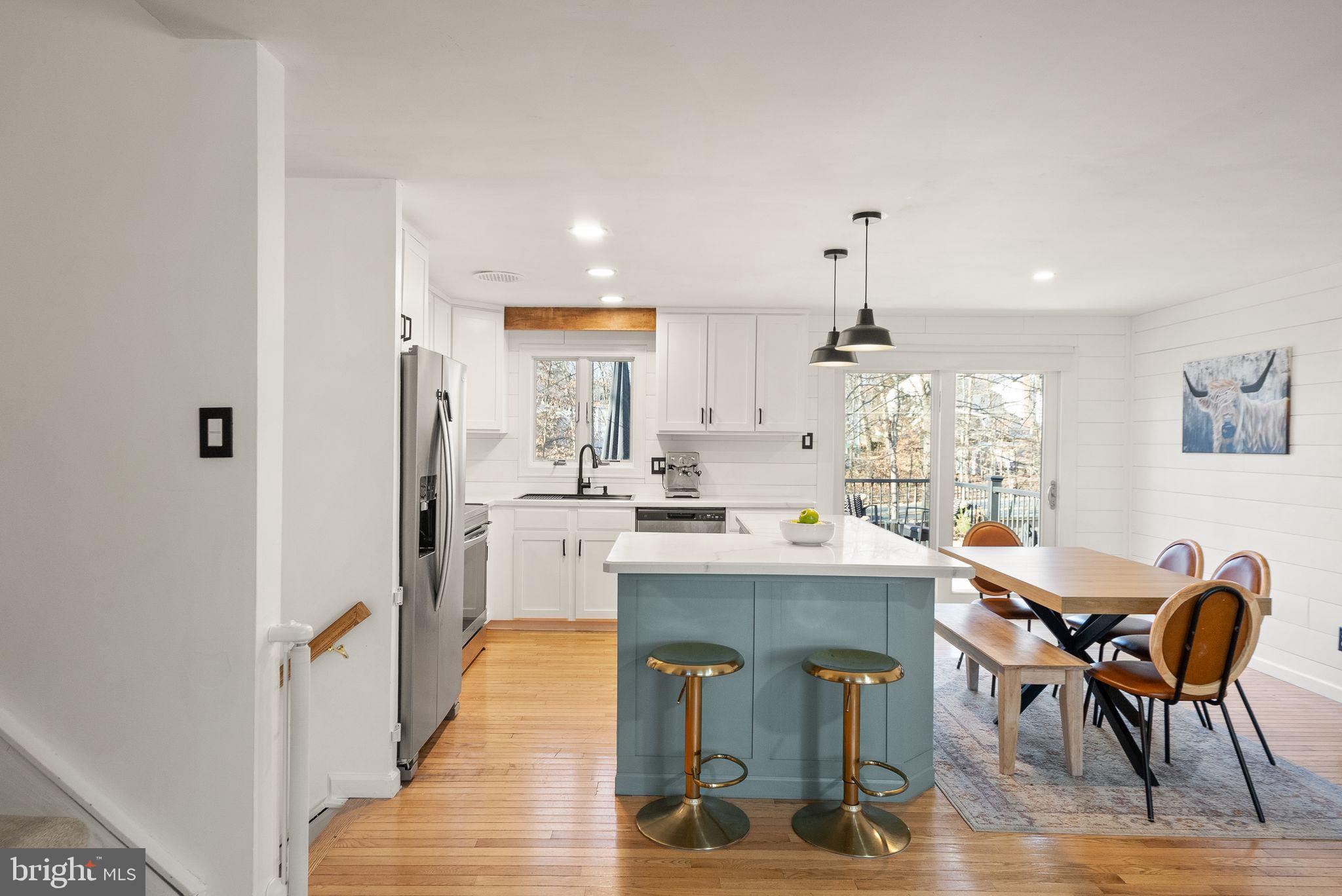 7902 Cliff Rock Court Springfield, VA 22153 - Photo 10 of 57 a kitchen with kitchen island a dining table chairs stainless steel appliances and cabinets
