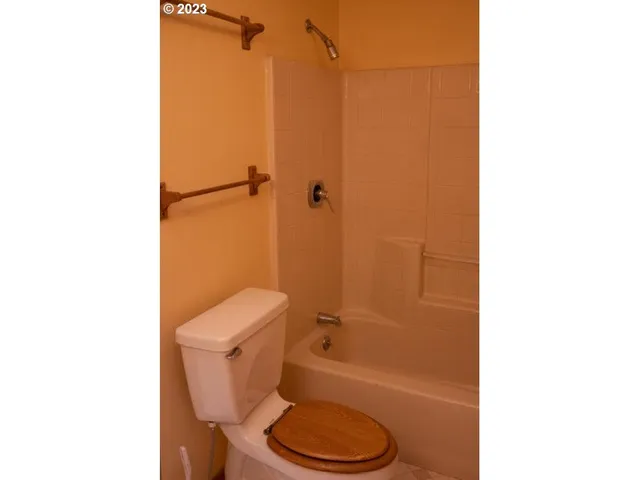 a view of a bedroom with a bed and wooden floor
