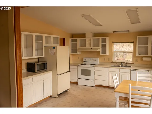 a kitchen with granite countertop white cabinets and white appliances