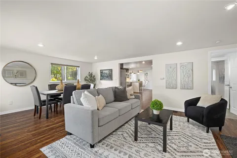 a living room with furniture a table a lamp and wooden floor