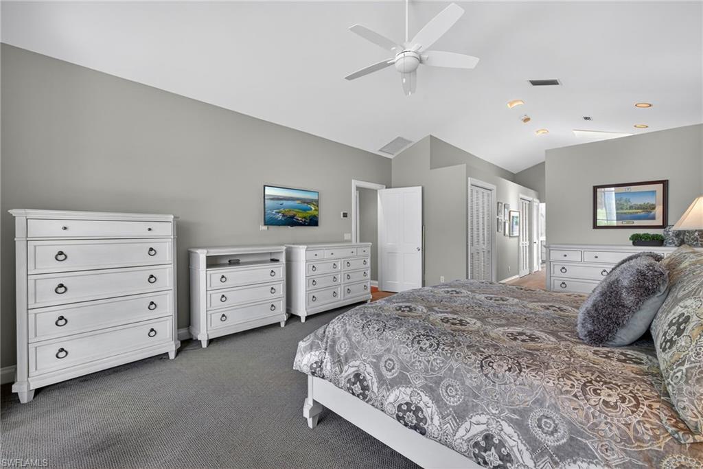6 Bramblewood Point Naples, FL 34105 - Photo 22 of 47 a bedroom with a bed a dresser and a chandelier