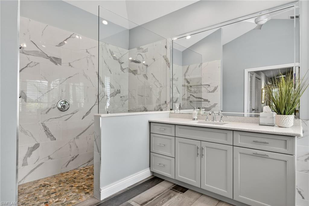 6 Bramblewood Point Naples, FL 34105 - Photo 23 of 47 a bathroom with a double vanity sink mirror and shower