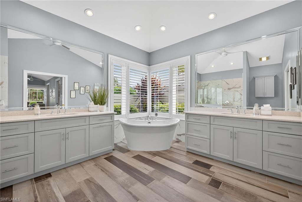 6 Bramblewood Point Naples, FL 34105 - Photo 24 of 47 a bathroom with a sink double vanity mirror and a bathtub