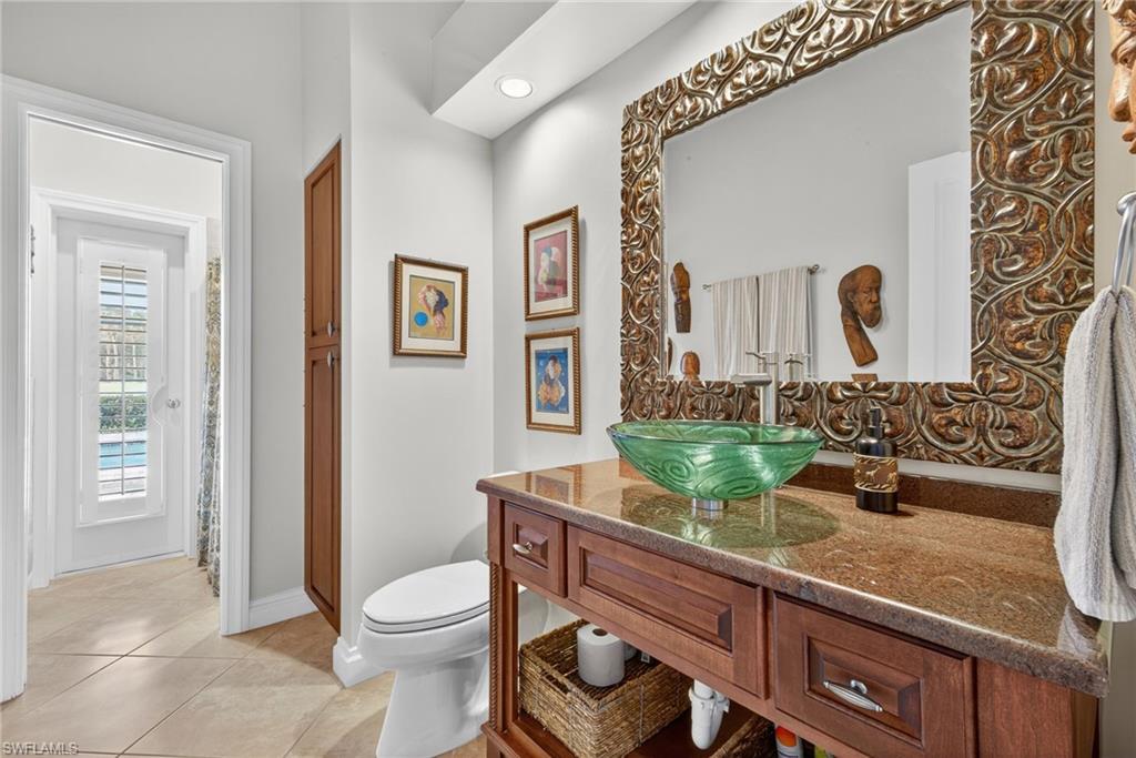 6 Bramblewood Point Naples, FL 34105 - Photo 30 of 47 a bathroom with a granite countertop sink mirror vanity and toilet