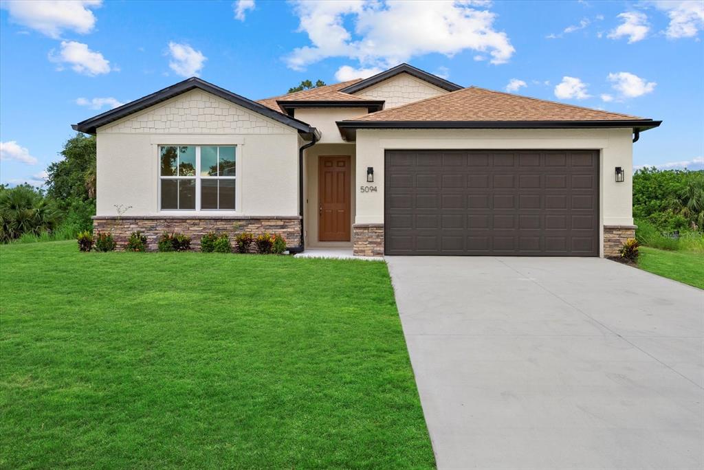 a front view of a house with a yard and garage