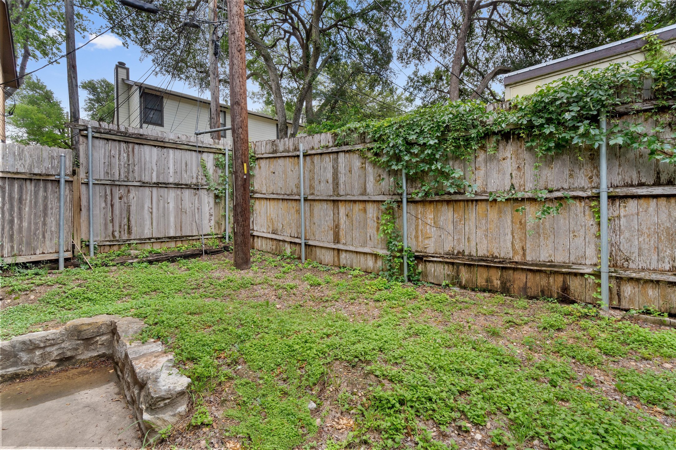 3415 Menchaca Road, Unit 113 Austin, TX 78704 - Photo 17 of 21 a view of backyard with large tree and wooden fence
